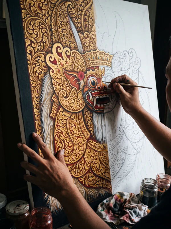 A Balinese painter working gold leaf into a Barong canvas